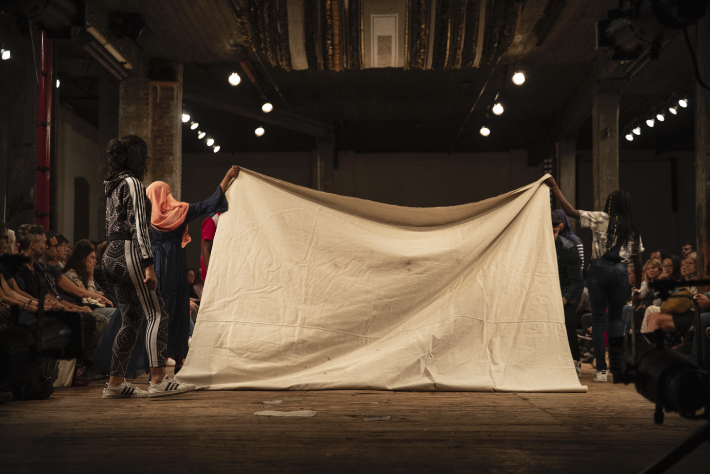 Performers fold a drop cloth